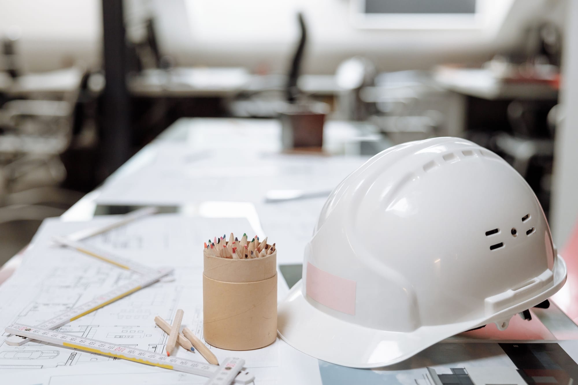 Capacete de segurança sobre plantas técnicas, em ambiente industrial